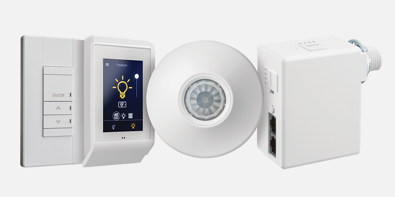 A collage of nLight Wired lighting controls products, including an occupancy sensor and wall switches.