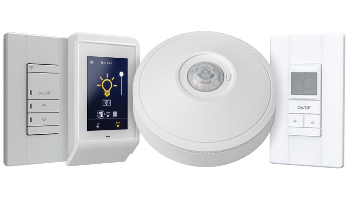 A collage of nLight lighting controls products, including an occupancy sensor and wall switches.